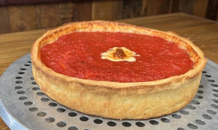 Comparison of stuffed pizza and deep dish pizza with a slice served
